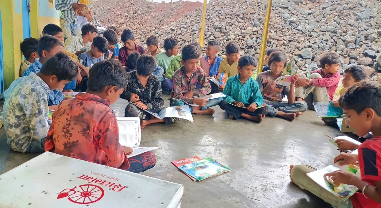 वाचनालय पेटी के चारों ओर पठन चक्र में बच्चे